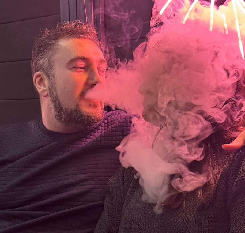 Alex Royle exhaling a cloud in a shisha lounge